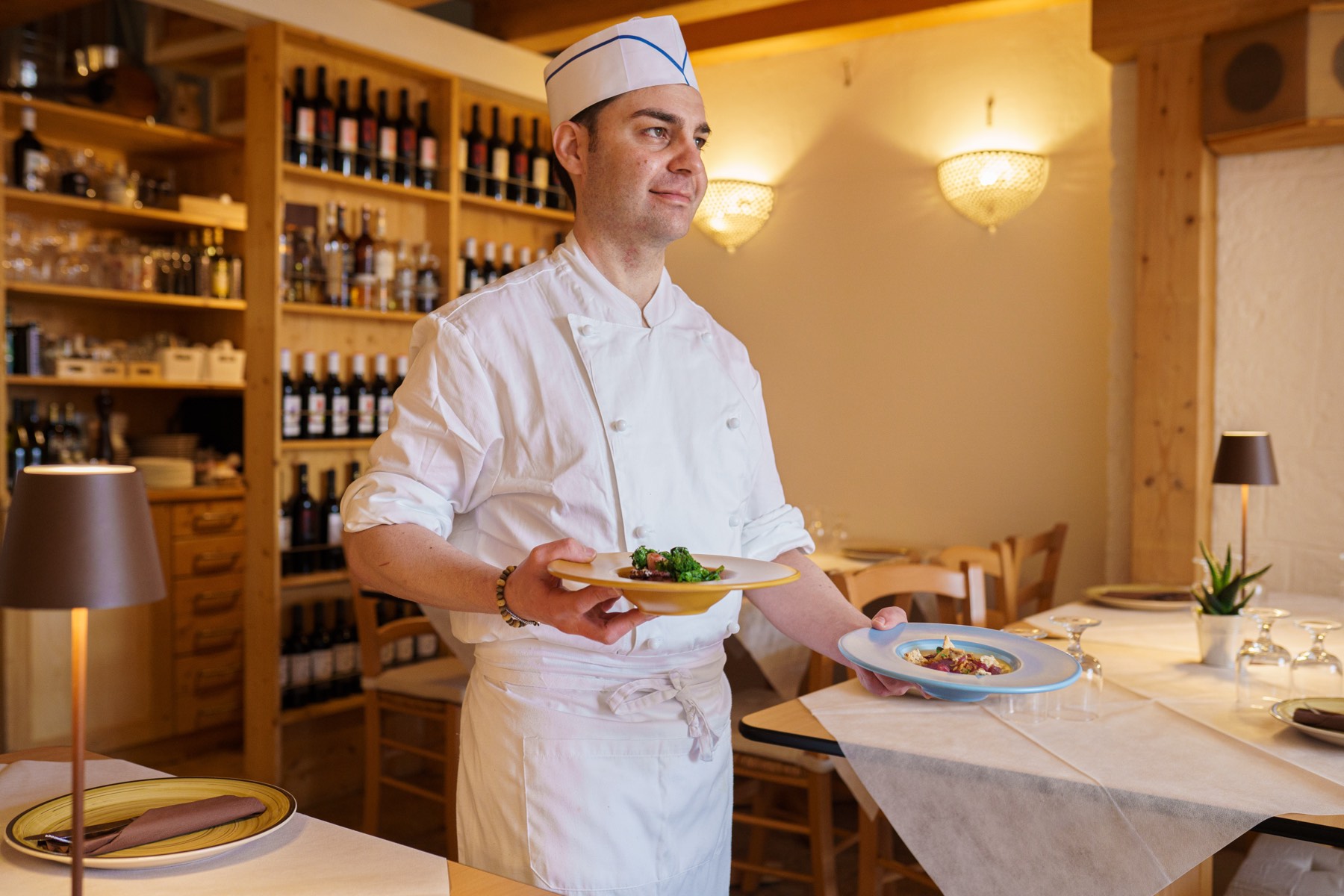 Le chef Mario Pellegrini en salle, deux assiettes à la main