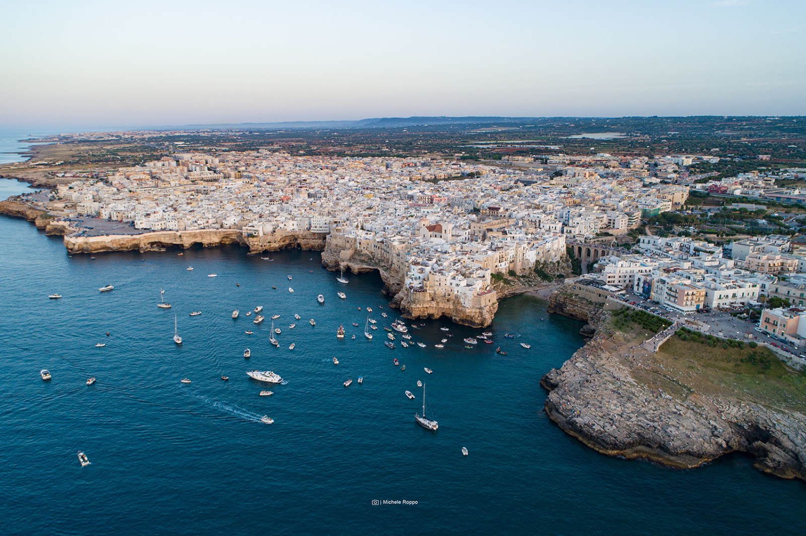 Polignano a Mare vue d'en haut au coucher du soleil, avec les bateaux en rade